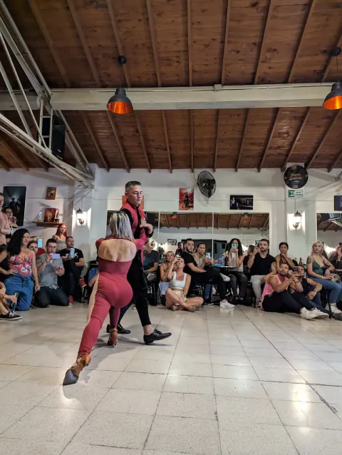 Pareja bailando en el centro de la pista mientras el público mira