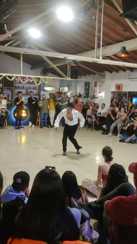 Bailarín improvisando durante un reto, con el público alrededor