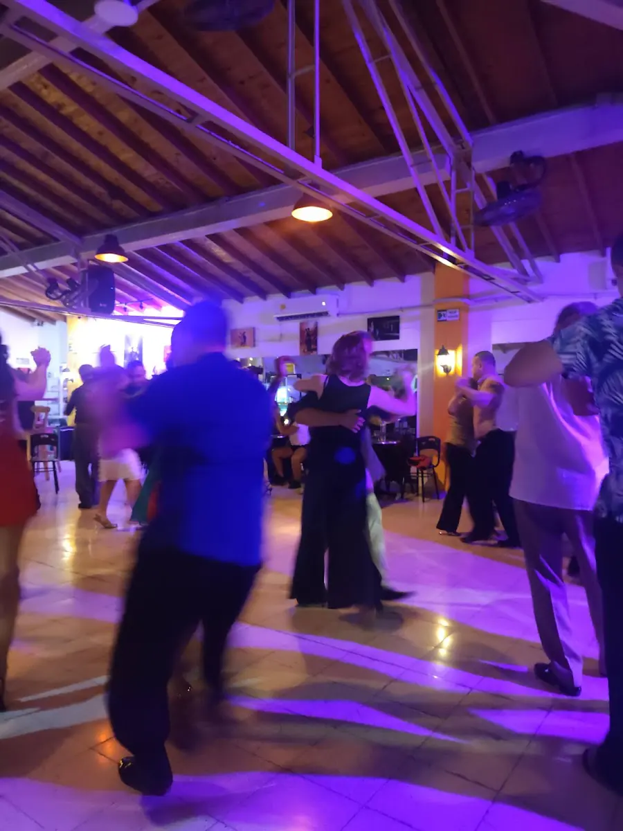 Parejas bailando en el social de Nueva Guardia con luces moradas
